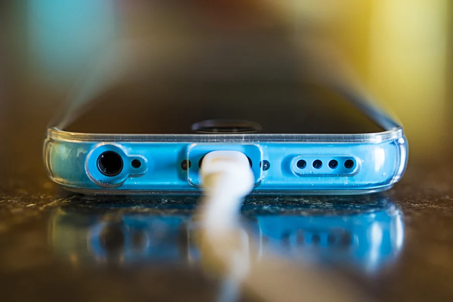 Smartphone bleu branché à son câble de charge