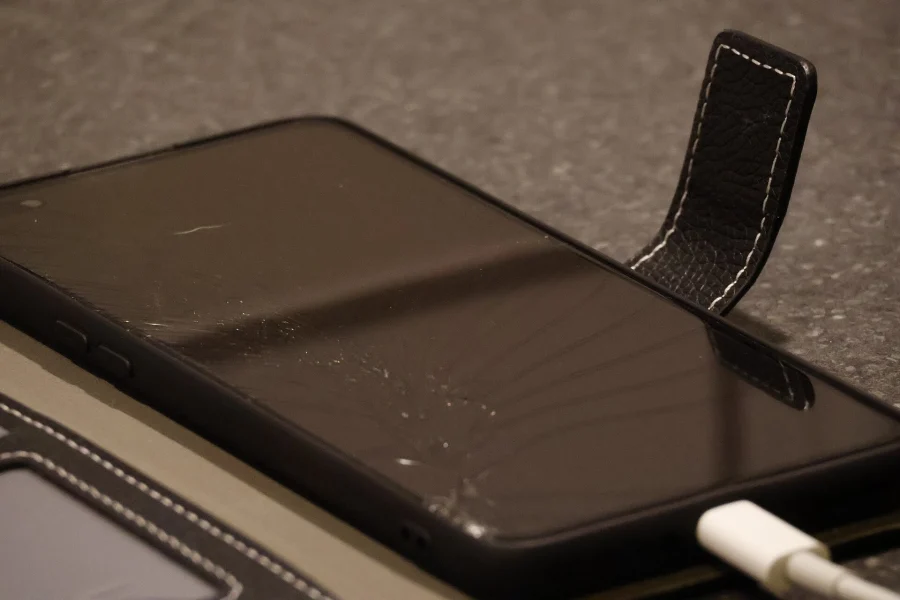 Smartphone OnePlus à l’écran endommagé posé sur une table