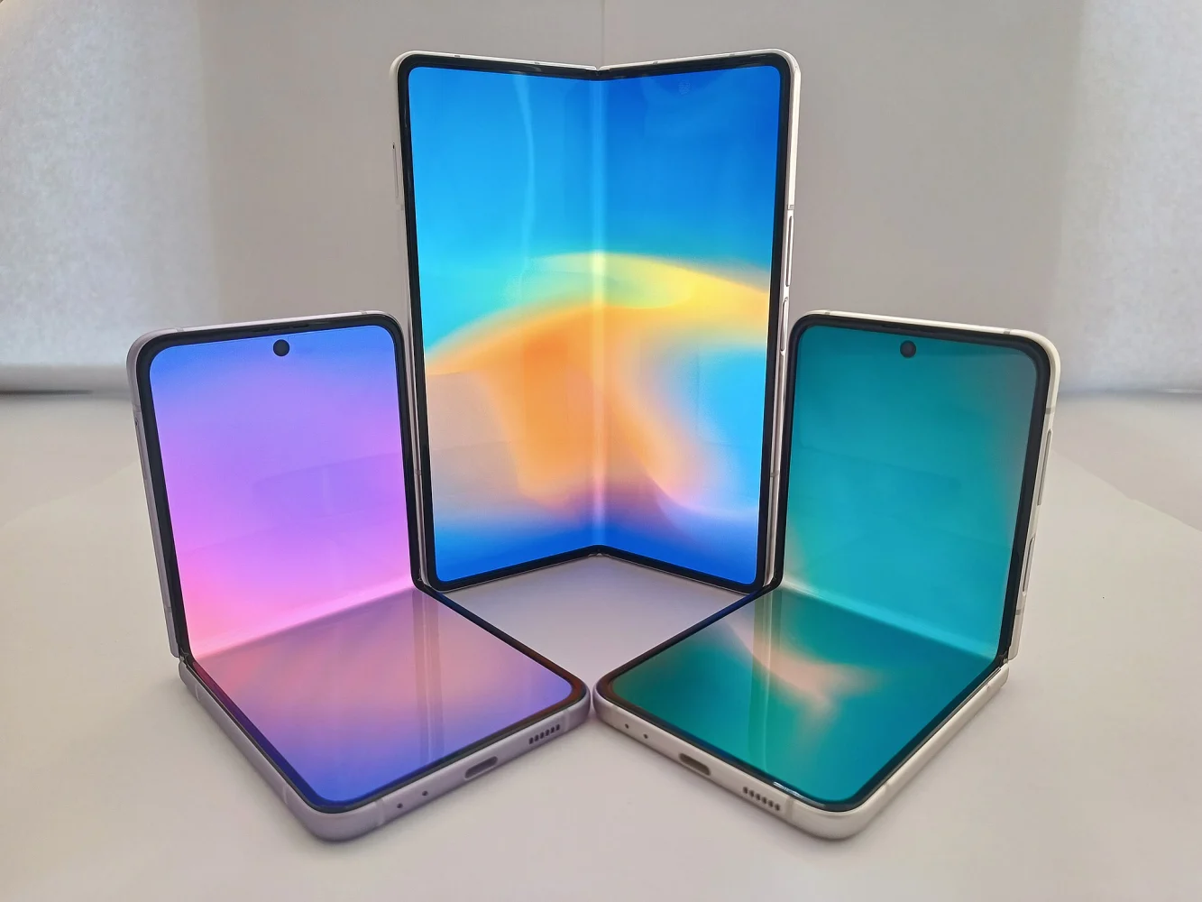Trois smartphones pliables ouverts côte à côte